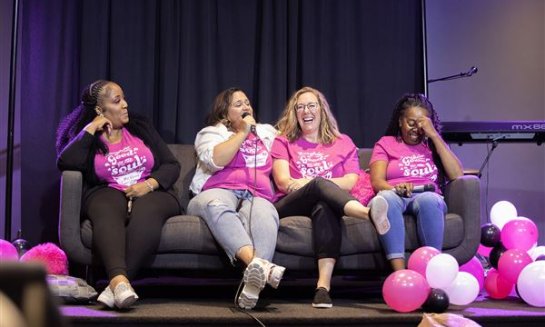 Panelists laugh as they share stories during the Spill the Beans women's conference, hosted by Vision Church, in 2023.